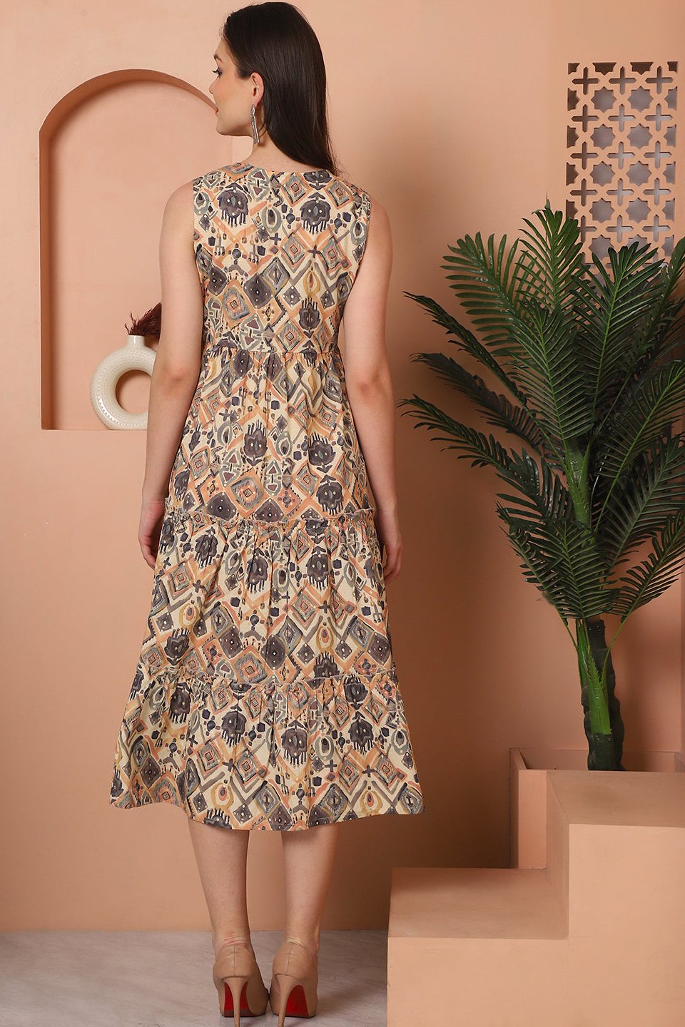 Back view of model in brown printed cotton dress
